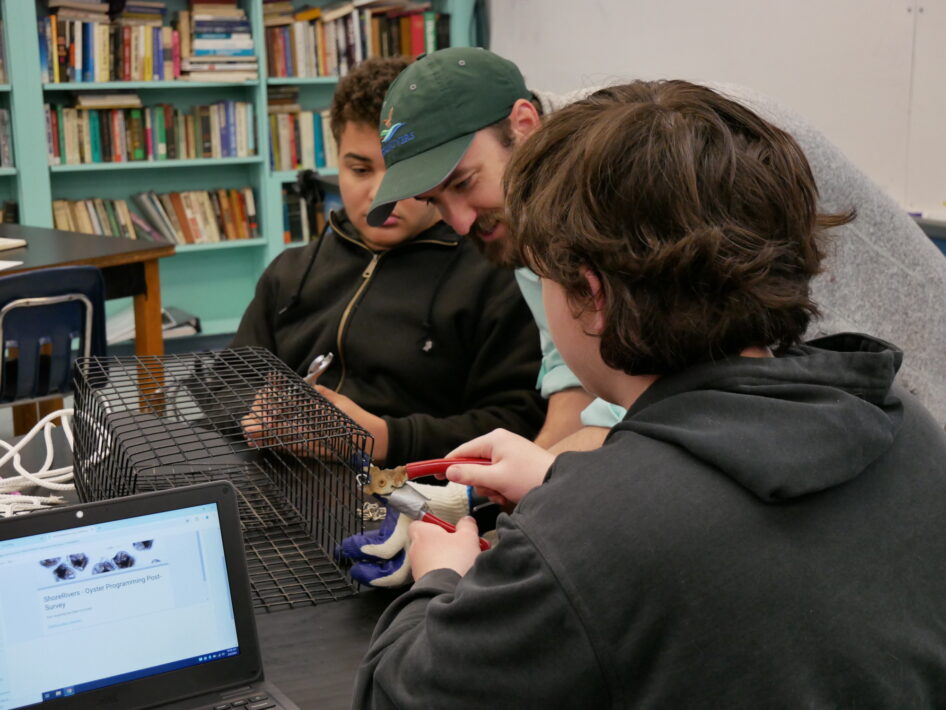 A ShoreRivers instructor helps two students assemble an oyster cage.