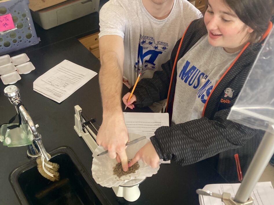 Two students weigh soil in a Morris Central School classroom.